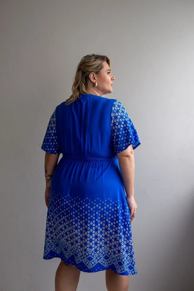 Plus size model wearing a blue patterned dress
