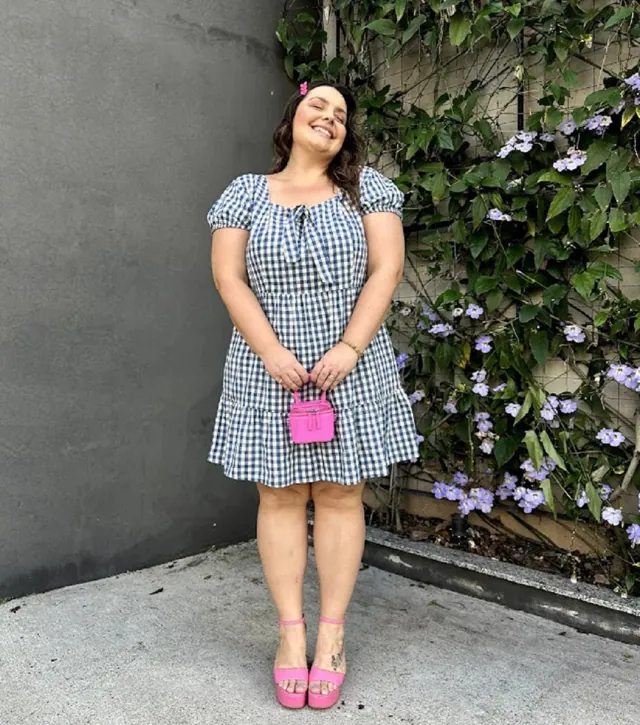 Plus size model wearing a gingham denim dress