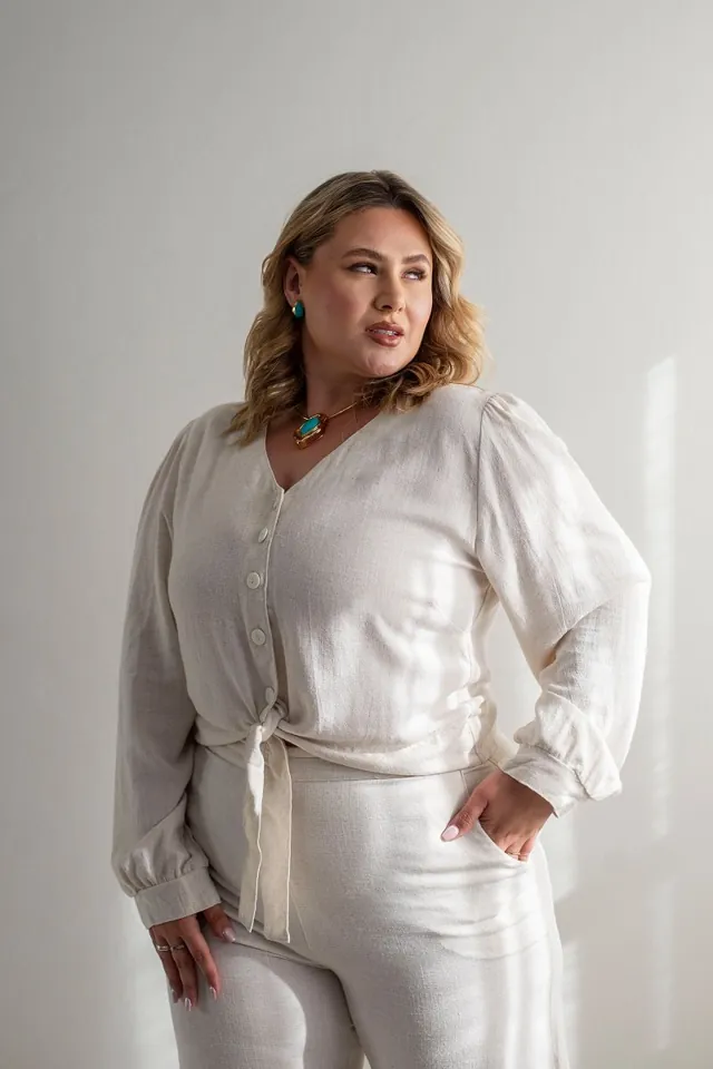 Plus size model wearing white linen wide-leg pants and a blouse
